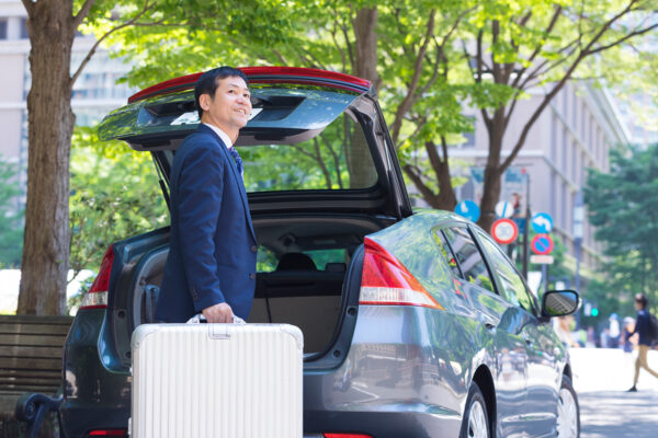 荷物を車で運ぶ男性